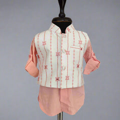 Traditional outfit with a light green embroidered vest and pink pants on a mannequin against a gray background.