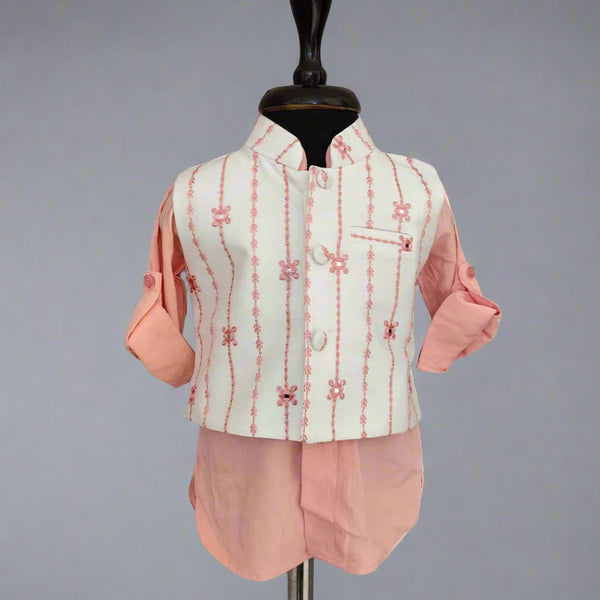 Traditional outfit with a light green embroidered vest and pink pants on a mannequin against a gray background.