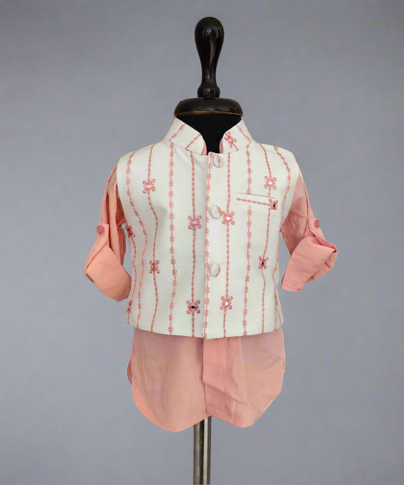 Traditional outfit with a light green embroidered vest and pink pants on a mannequin against a gray background.