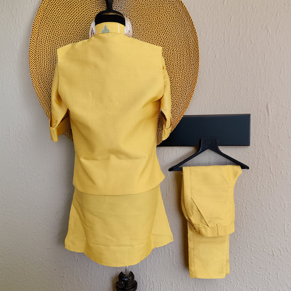 Yellow outfit on a mannequin and hanger against a plain wall