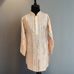 Mannequin wearing a long, patterned coat against a plain background