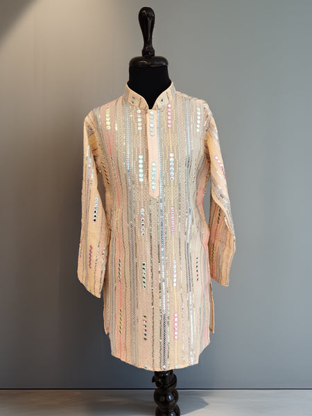 Mannequin wearing a long, patterned coat against a plain background