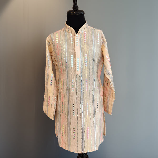 Mannequin wearing a long, patterned coat against a plain background