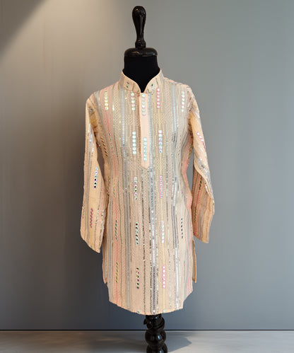 Mannequin wearing a long, patterned coat against a plain background