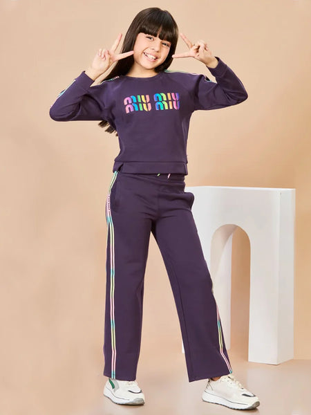 Child wearing a purple outfit with colorful text on a beige background