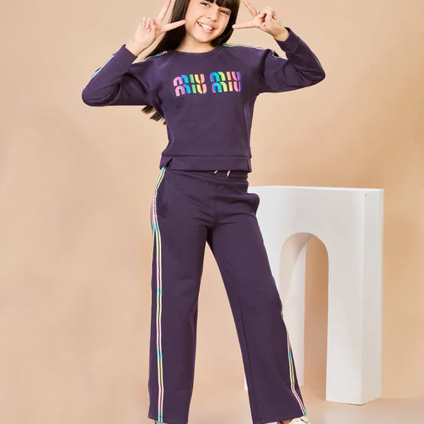 Child wearing a purple outfit with colorful text on a beige background