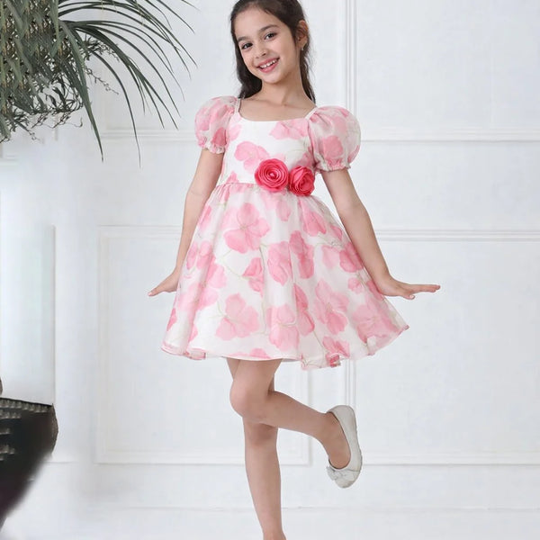 Young girl wearing a pink floral dress against a white background