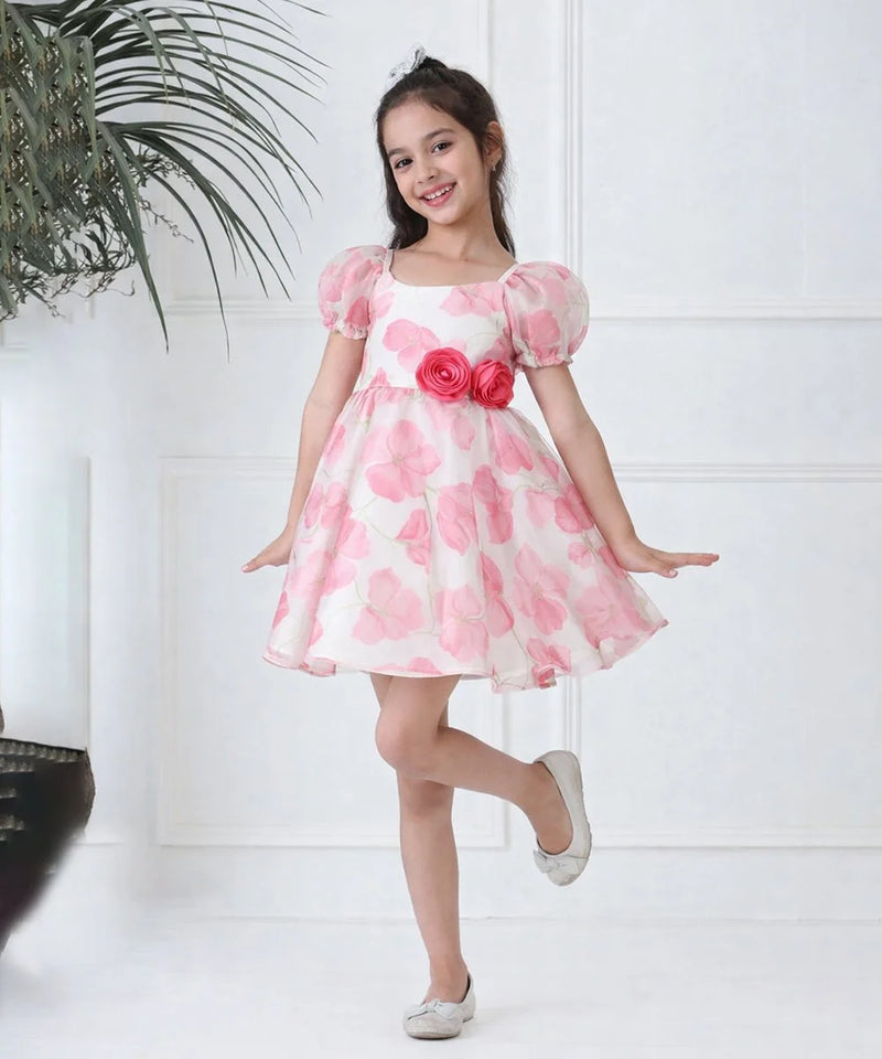 Young girl wearing a pink floral dress against a white background