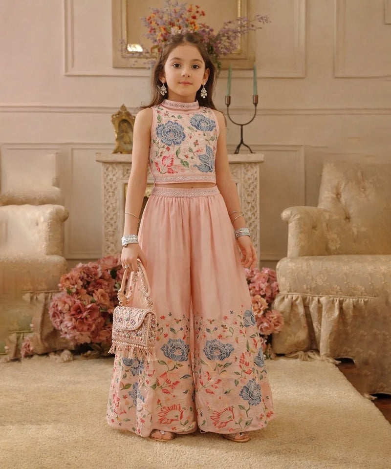 Young girl in a floral outfit standing in an elegant room with floral decorations.