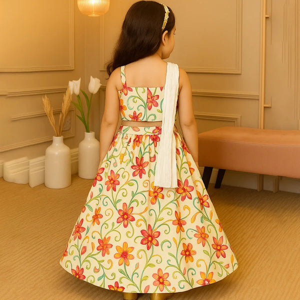 Young girl wearing a floral dress in a room with beige walls and a vase of flowers.