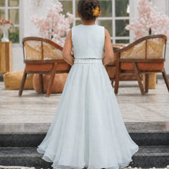 Young girl in a light blue dress standing on steps with a decorative background