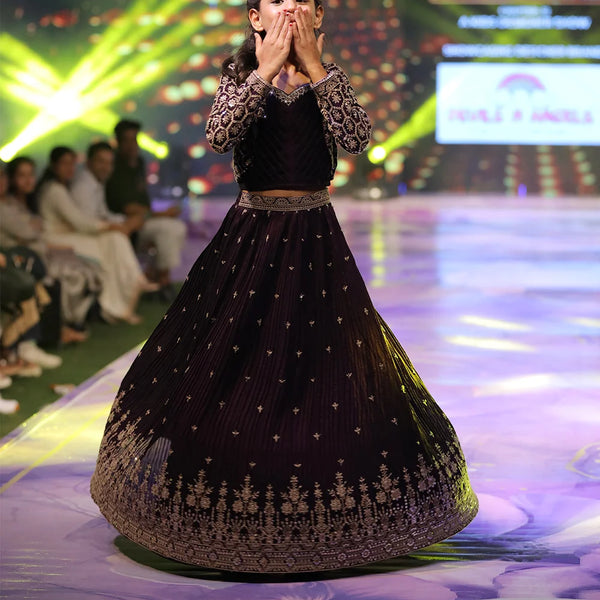 Girl wearing a dark purple lehenga on stage in Jaipur