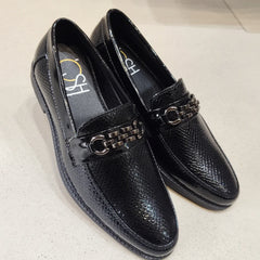 Black loafers with chain detail on a light gray background