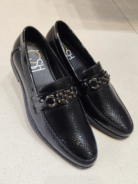 Black loafers with chain detail on a light gray background