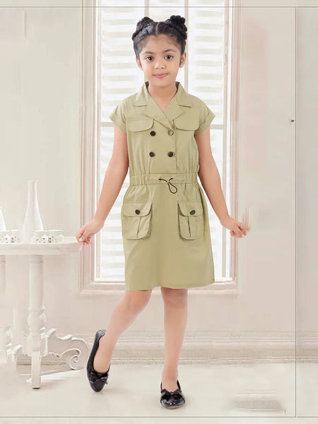 A girl standing in a room wearing a green midi party wear dress with short sleeves, belt, and pockets.