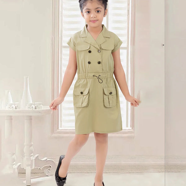 A girl standing in a room wearing a green midi party wear dress with short sleeves, belt, and pockets.