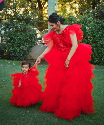 It’s a red Colored  ruffle layered gown for a mother-daughter duo, a perfect marriage party dress for a girl.
