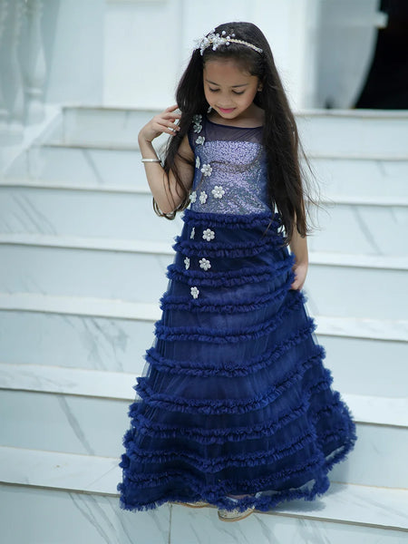 Young girl in a blue formal gown standing on steps.