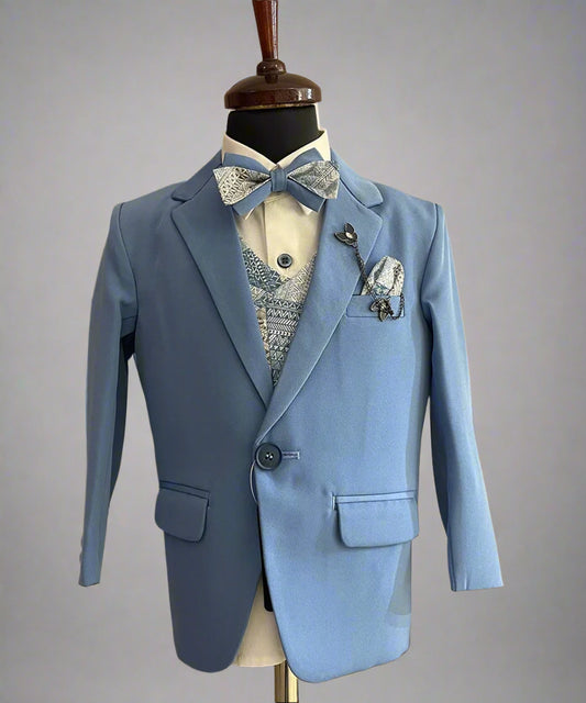 This coat suit for boys consists of a coat, matching pants, a self-printed waistcoat, and a white Colored shirt. It features a matching printed bow, a broach and a printed pocket square.