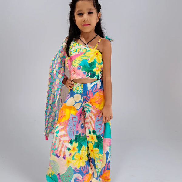Young girl wearing a colorful floral dress on a plain background