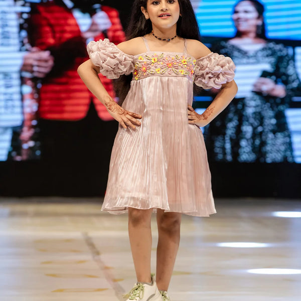 It’s a very light onion pink Colored girl party dress online that’s perfect for occasions. It features designer floral work and a smocking sleeves