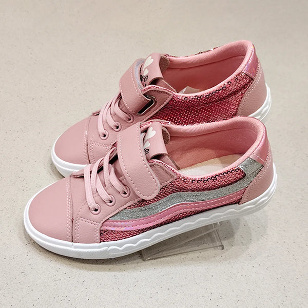 Pair of pink children's sneakers with white soles on a light gray background