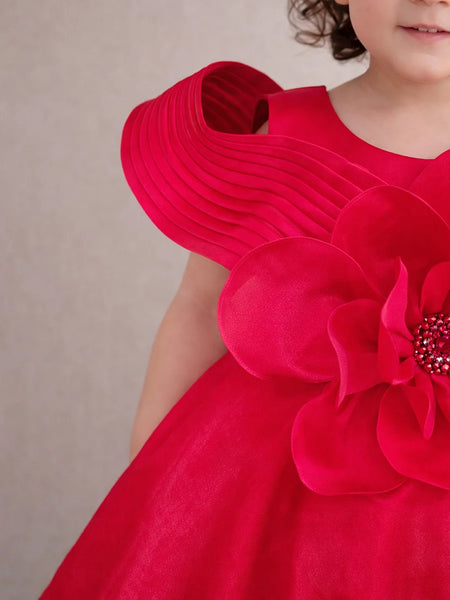 Red dress with a large floral embellishment on a plain background