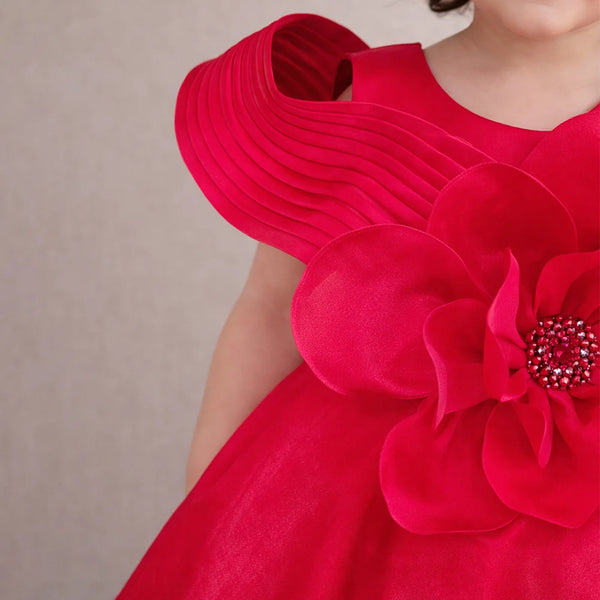 Red dress with a large floral embellishment on a plain background