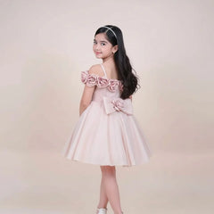 Young girl wearing a pink dress with floral details on a beige background