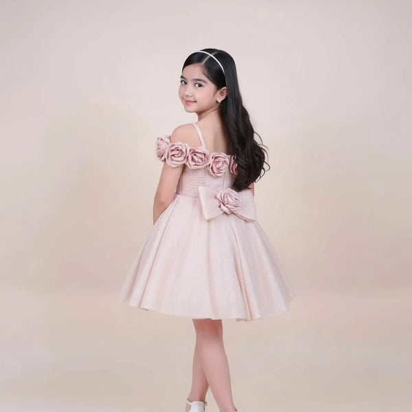 Young girl wearing a pink dress with floral details on a beige background