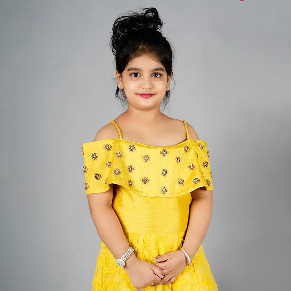 Yellow off-shoulder dress with floral details on a gray background