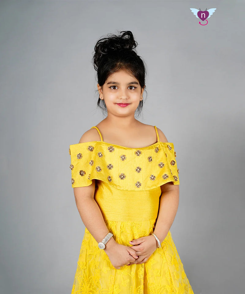 Yellow off-shoulder dress with floral details on a gray background