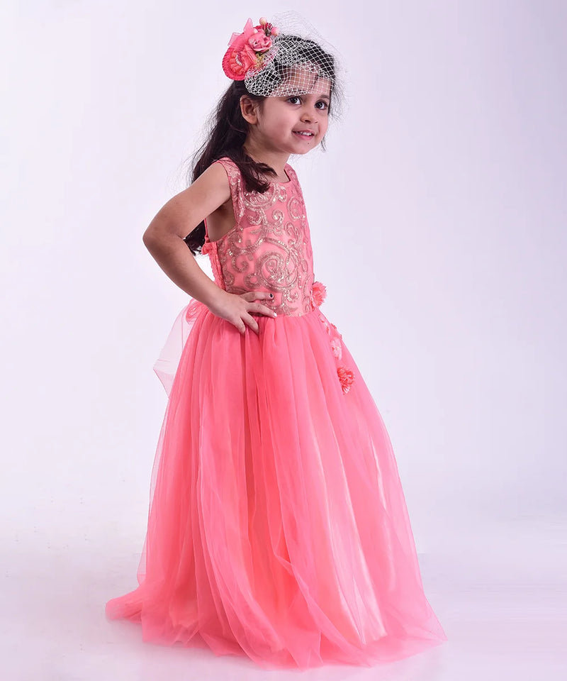 Young girl in a pink dress with floral headband on a white background