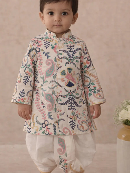 Child wearing a traditional embroidered outfit with a neutral background
