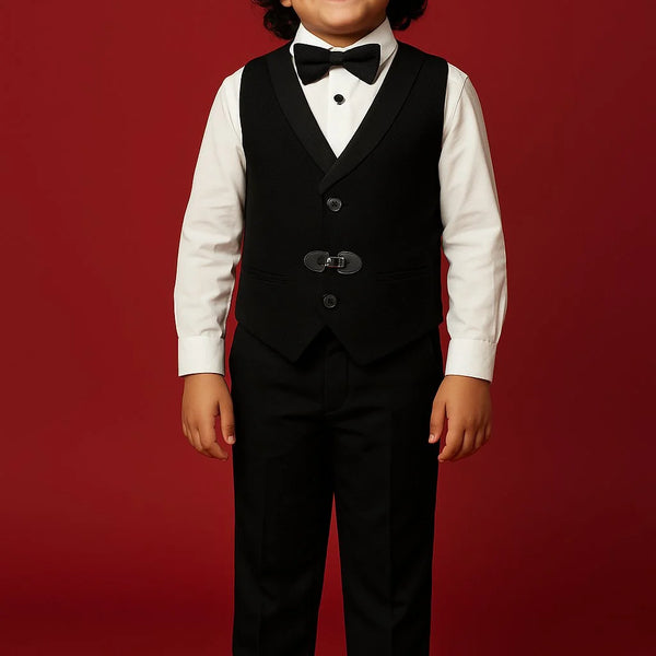 Child wearing a formal black suit with a bow tie on a red background
