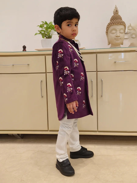 Side view of magenta color embroidery sherwani for boys for wedding with matching white pajama 