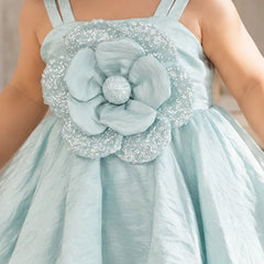 Close-up of large layered 3D flower appliqué on the waist of pastel blue baby girl frock