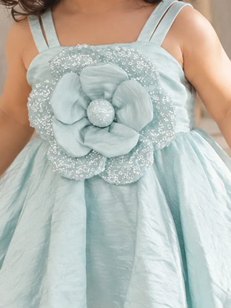 Close-up of baby girls' pastel blue frock 3D flower