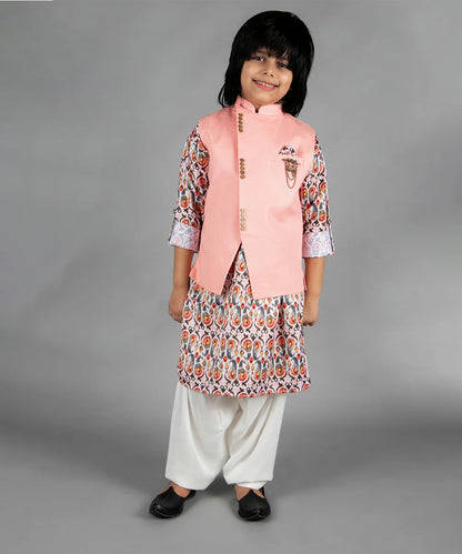 Representing this beautiful sleeveless solid jacket in peach with a golden broach and a pocket square, paired with a soft cotton blend kurta and matching cream colored Patiala.