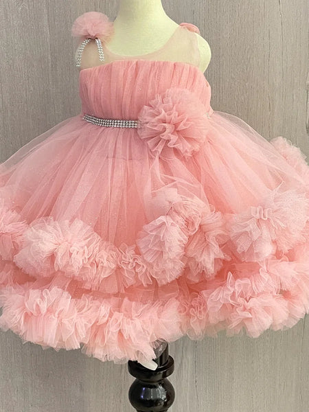 Pink Colored birthday wear frock that comes with a fancy belt attached on the waist and a beautiful floral detailing. 
