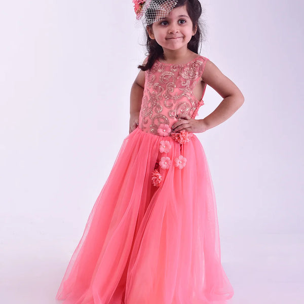Young girl in a pink gown with floral details on a white background