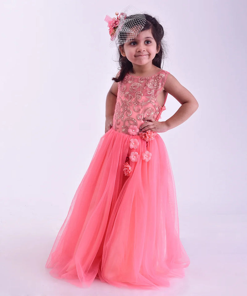 Young girl in a pink gown with floral details on a white background