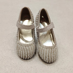 Pair of pearl-beaded shoes on a beige background