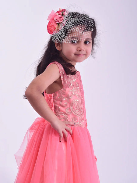 Young girl in a pink dress with floral headband on a white background