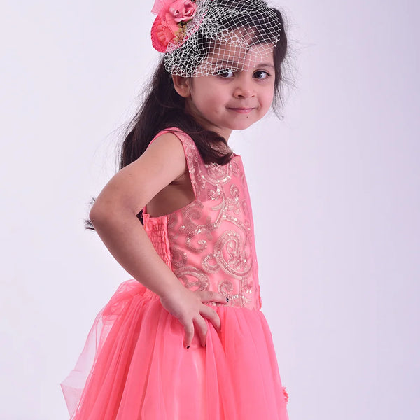 Young girl in a pink dress with floral headband on a white background