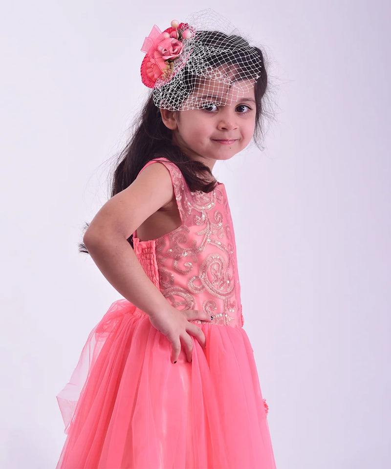 Young girl in a pink dress with floral headband on a white background