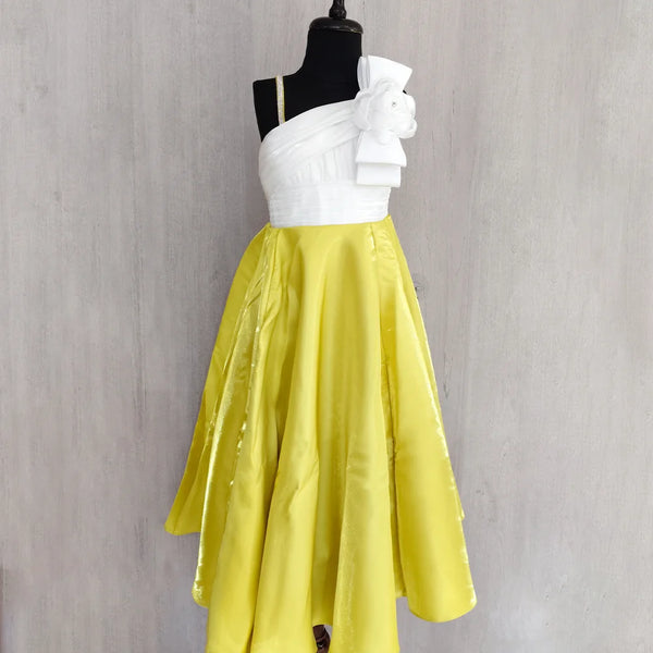 White top and yellow skirt on a mannequin against a gray background