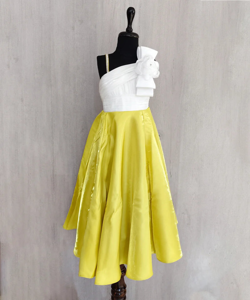 White top and yellow skirt on a mannequin against a gray background