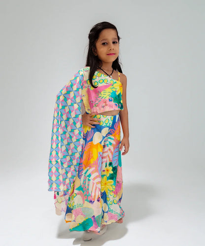 Young girl wearing a colorful outfit with a patterned shawl on a white background