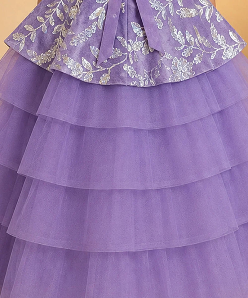A close-up of a purple tiered tulle dress or skirt with a matching waist sash and silver floral embroidery on the upper ruffled section.